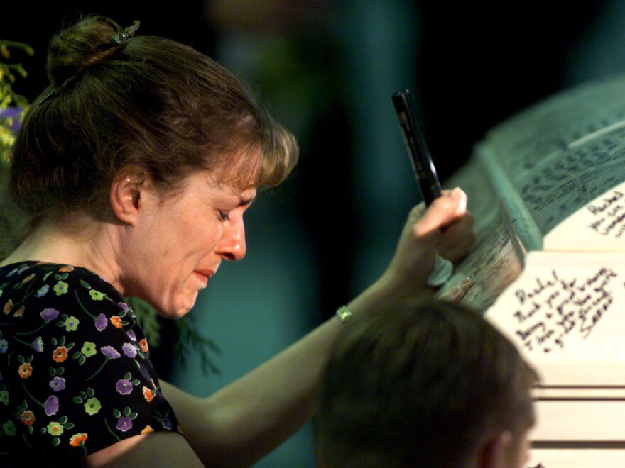 Columbine High School teacher Paula Reed is overcome with grief after signing Rachel Scott's casket during funeral services on April 24, 1999.