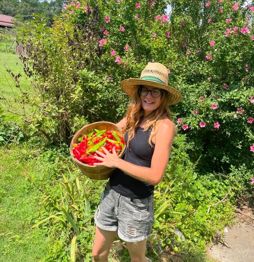 Ali Simpson, 36, holds a basket of peppers grown on Kimberly Ann Farms in Ten Mile, Tennessee. Simpson has grown produce and raised a small number of livestock and other animals on the property full time since 2022.