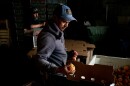 Jose Alfredo Rosas Luly works on packing up peaches as Napoleon Caromla builds cardboard bushel boxes at Flamm Orchards in Cobden, Illinois.  A cold spell in late December damaged peach crops across southern Illinois, with some orchards estimating nearly a 90% loss.