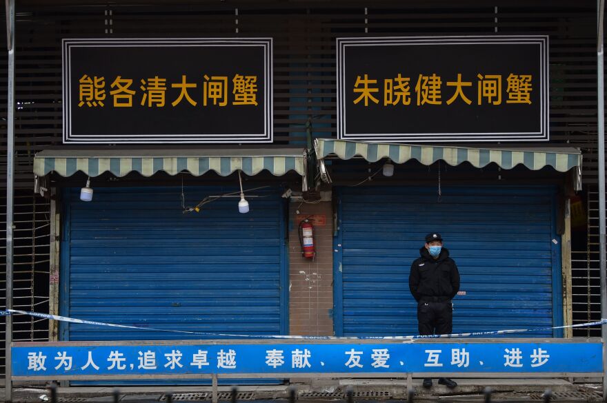 A security guard stands outside the Huanan Seafood Wholesale Market, where the novel coronavirus was detected in Wuhan, China.