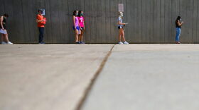Students wait in line for registration and an identifying wristband after receiving a negative test result for coronavirus while arriving on campus at Colorado University in Boulder, Colorado. 