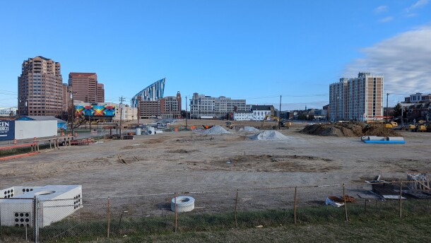 Undeveloped lots contain piles of dirt and construction equipment.