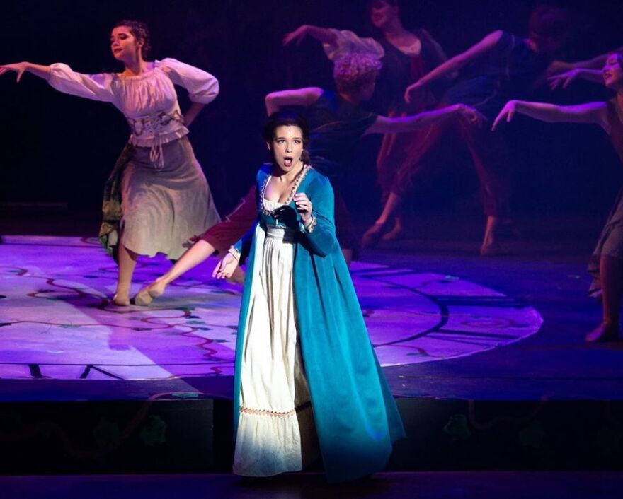 Girl in costume on stage singing 