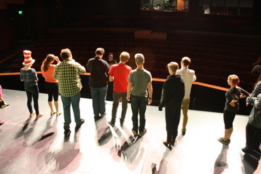 Cast members gather at the edge of the stage to talk with director WT McRae and musical director Andrew Hames, during a rehearsal of “Seussical the Musical” Wednesday at the Sitka Performing Arts Center. The full-scale musical will open Friday night after just two weeks of rehearsal. (KCAW photo by Ed Ronco)