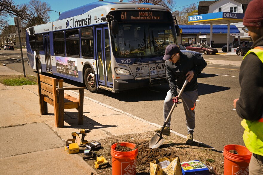 Dimitris Koutoumbas with Connecticut Urbanists works at a bus stop on Maple Avenue and Brown Street in Hartford on April 11, 2026. Members of Connecticut Urbanists, a safe streets advocacy group, have placed more than 30 benches at bus stops in the Hartford region. About half are in South Hartford neighborhoods.