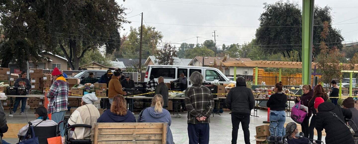 People line up at Martin Park in downtown Fresno on a cloudy day to receive food. Photo taken by Israel Cardona Hernández.