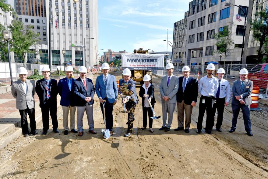 Akron Mayor Dan Horrigan scoops the first shovel of dirt for the Main Street project.