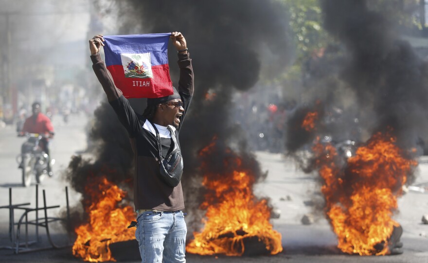 A protester waves a Haitian flag during demonstrations