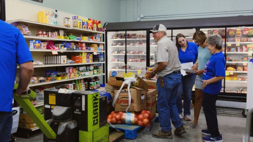 Axtell Community Grocer’s investors volunteer to help the store stock shelves when their orders arrive.