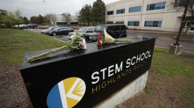 Bouquets of flowers sit on the sign outside the STEM School Highlands Ranch late Wednesday, May 8, 2019, in Highlands Ranch, Colo. A shooting took place Tuesday at the charter school south of Denver. (David Zalubowski/AP)