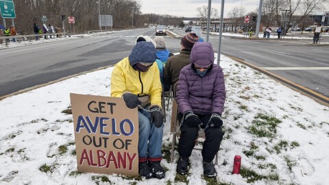 Indivisble Albany protestors outside of the Albany International Airport, recreating the seating arrangements deportees endure during their flight on November 30th, 2025.