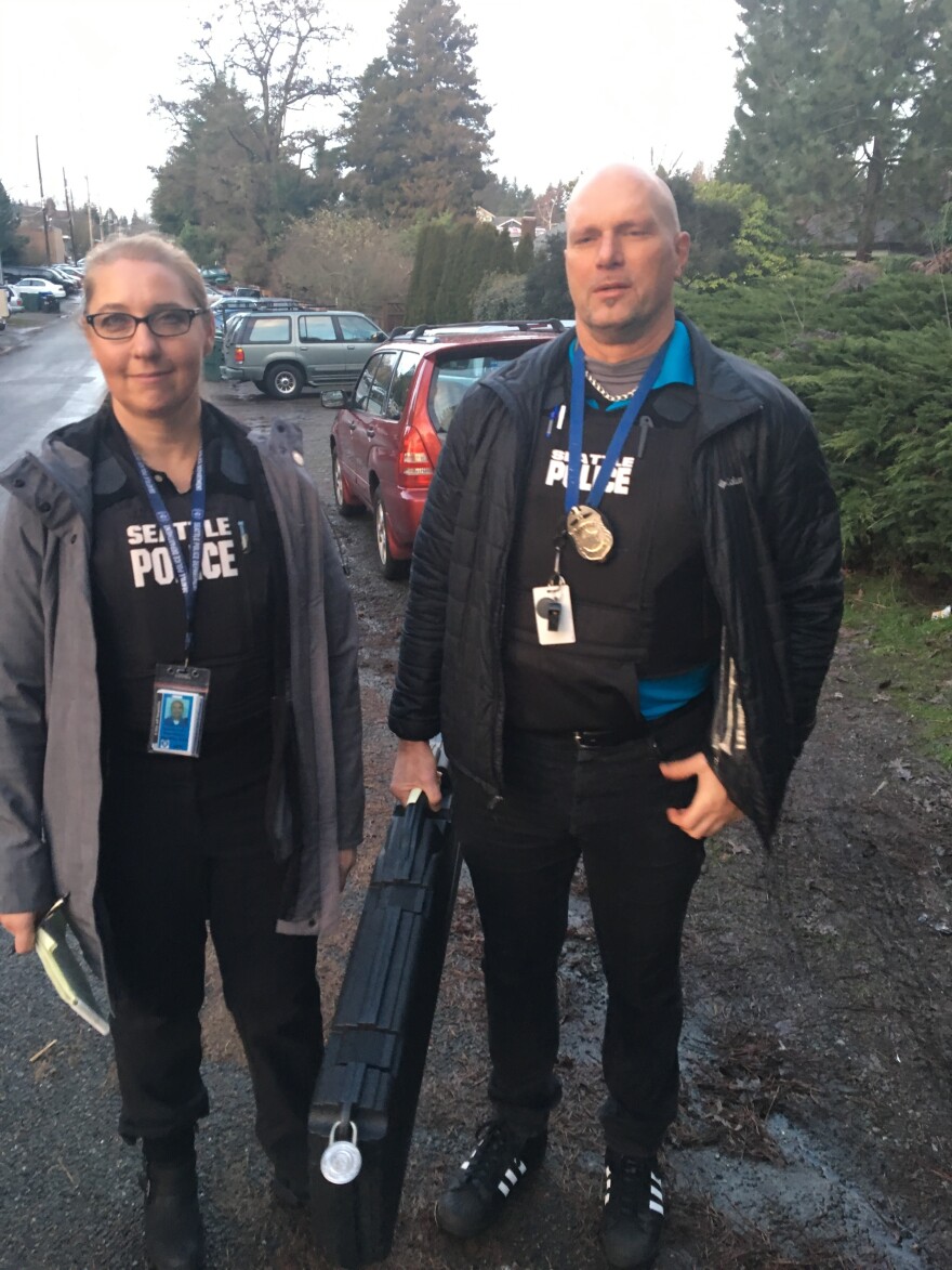 Seattle Police Sgt. Dorothy Kim and Officer Sean Hamlin, holding the semi-automatic rifle they've just removed from the home of a man arrested on domestic violence charges.