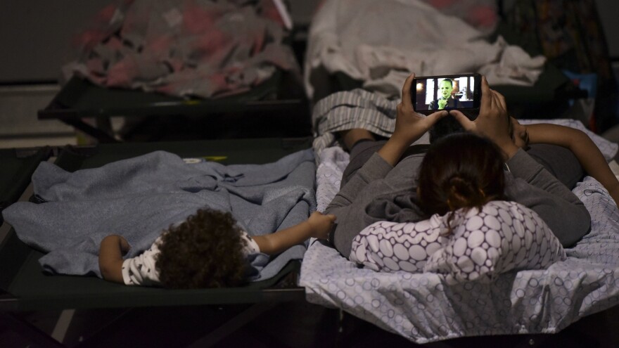 A woman and a child wait out Hurricane Maria at Humacao Arena in eastern Puerto Rico. By Wednesday morning, more than 11,000 people on the island had gone to shelters, the governor said.