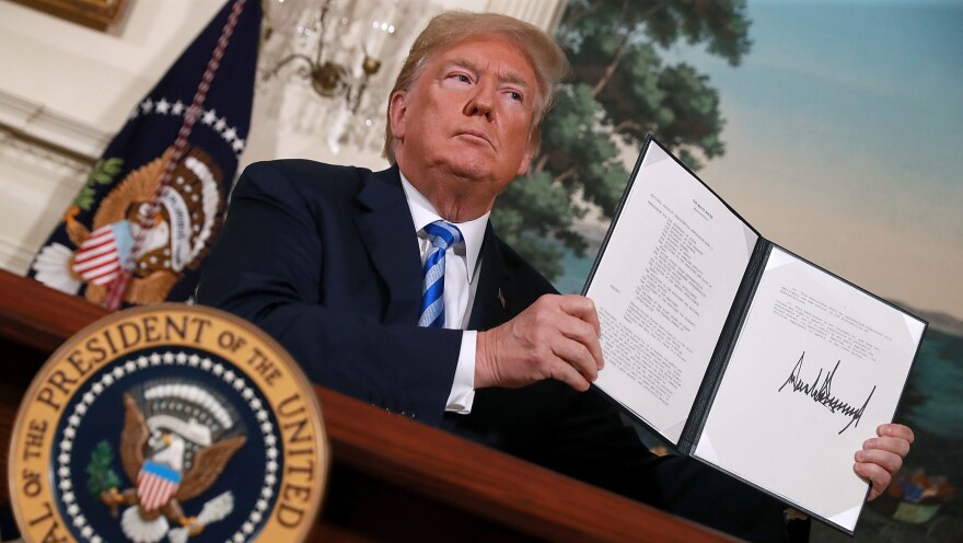 President Trump displays a memorandum Tuesday marking his decision to withdraw the U.S. from the 2015 nuclear deal. Moments later, as he left the Diplomatic Room at the White House, he told reporters that Secretary of State Mike Pompeo was on his way to North Korea.