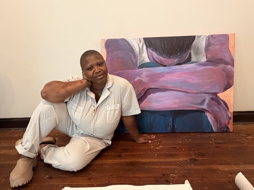Destiny Brady poses with artist Isissia Drake's work, "Heavy."