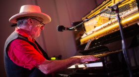 A person plays the piano inside a studio. 