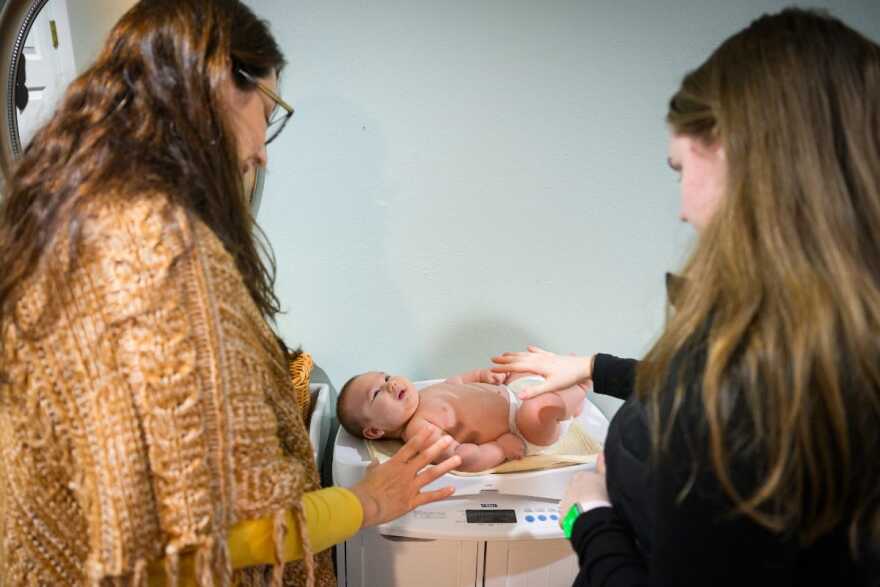 Lactation consultant Beth Waters, left, and Rebekah Wong, right, weigh 3-month-old Reuel Wong after a breastfeeding session at Andaluz Waterbirth Center in Portland, Oregon to see how much breastmilk he consumed. Waters has been working with Reuel’s mother, Rebekah, throughout her pregnancy and postpartum period.