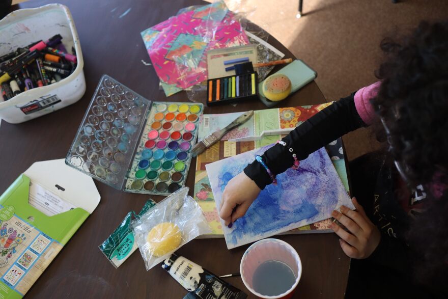 A student paints in a room stocked with arts supplies at the Eastern Iowa Arts Academy in Cedar Rapids.
