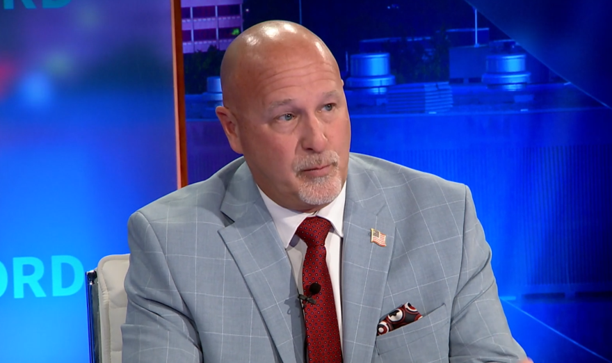A man sitting at a desk on a news show.