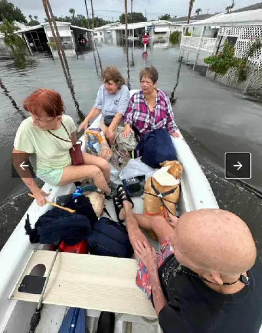 Residents and their dog evacuate by boat through a flooded Sarasota County neighborhood after Tropical Storm Debby inundated streets in August.