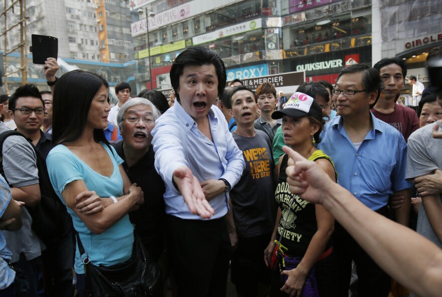 Angry locals confront pro-democracy student protesters, demanding that they remove the barricades blocking local streets in Causeway Bay.