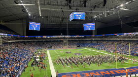 First responders treat an injured service member following a fall at the Alamodome Saturday.