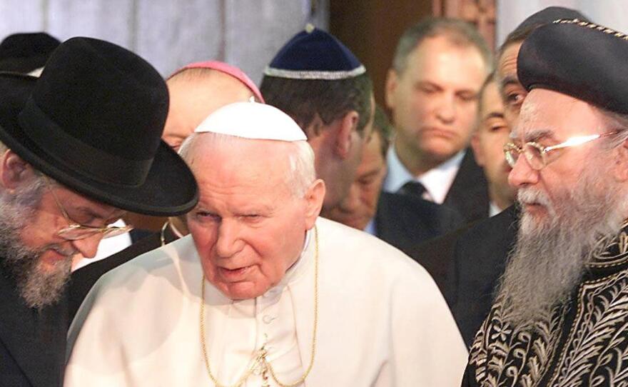 Pope John Paul II speaks to Israel's two head rabbis, Meir Lau (left) and Eliahu Bakshi-Doron (right), during his visit to Jerusalem in 2000. The pontiff reached out to both Jews and Muslims on his trip and was warmly embraced. His successors as pope, Benedict XVI and Francis, have also visited the Holy Land.