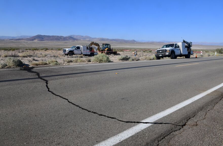 A crack on Highway 178 is seen as construction workers fix a broken water line south of Trona.