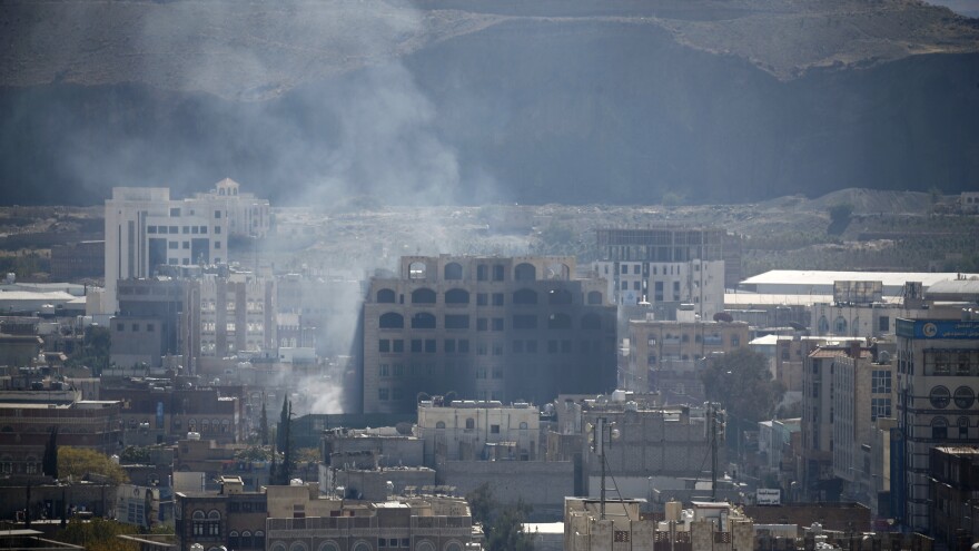 Smoke billows behind a building in the Yemeni capital Sanaa on Sunday, during clashes between Houthi rebels and supporters of Yemeni ex-president Ali Abdullah Saleh.