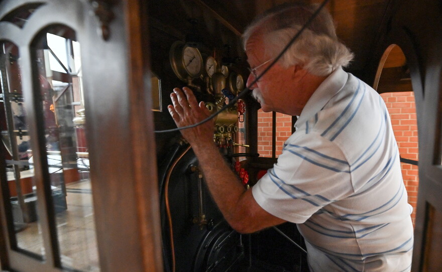 Dan Hryhorcoff kneels in the cab of the replica train he built.