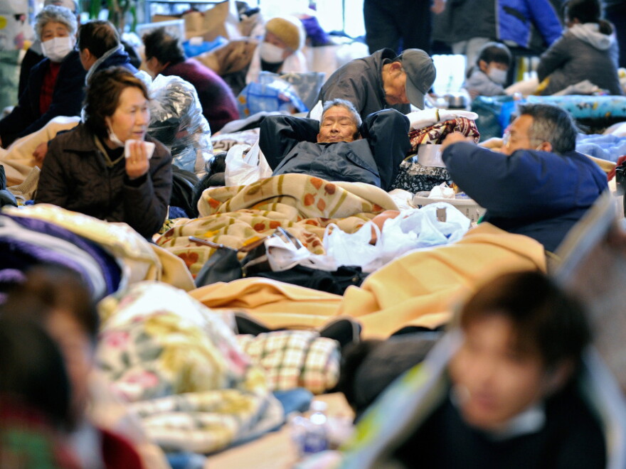People rest on the floor at a evacuation center after the recent tsunami and earthquake in Natori, Miyagi prefecture, on Wednesday.