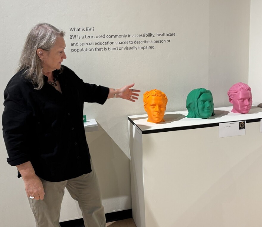 Director of Gallery and Outreach at NKU points to the opening of the exhibit Tactile Revolutions, called Meet the Team.