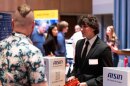 Young man visits a booth at a job fair.