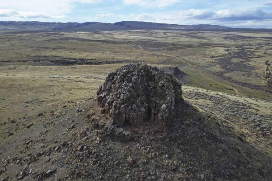 Sentinel Rock stands near a massacre site which juts above sagebrush and high grass used by roaming cattle herd on April 24, 2023, near Orovada, Nev. Native American tribes and environmentalists say the open-pit mine at Thacker Pass will harm wildlife habitats, degrade groundwater and pollute the air in a remote region dotted with sagebrush. (AP Photo/Rick Bowmer)