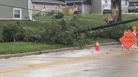 A downed power line, broken tree, and road closed sign from Aug 13 thunderstorms in Bloomington Normal.