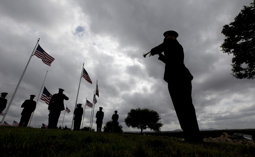 A rifle squad fires a salute at the conclusion of the ceremony as a bugler plays taps for Army Sgt. Charles Schroeter.