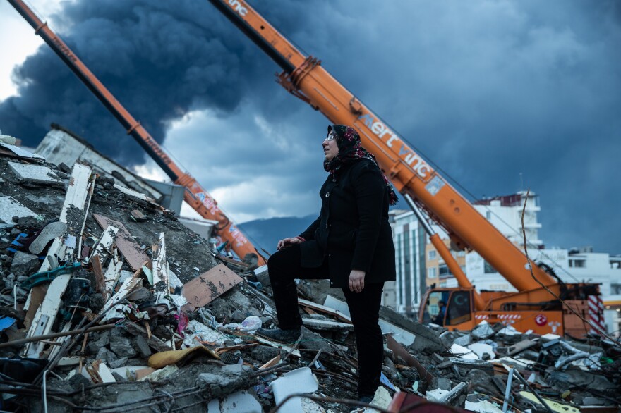 A woman waits for news of her loved ones who are believed to be trapped under collapsed building in Iskenderun, Turkey on Tuesday.