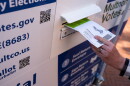 A voter drops off their ballot at a Multnomah County ballot drop box in Pioneer Courthouse Square in May 2026.