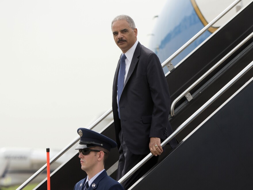 Attorney General Eric Holder arrives on a military aircraft at Lambert-St. Louis International Airport in St. Louis on Aug. 20. He was traveling to Ferguson, Mo., to check in on the federal government's investigation into the Aug. 9 shooting of 18-year-old Michael Brown by a police officer.