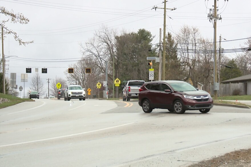 A red vehicle turns onto North Smith Road from East Tenth Street.