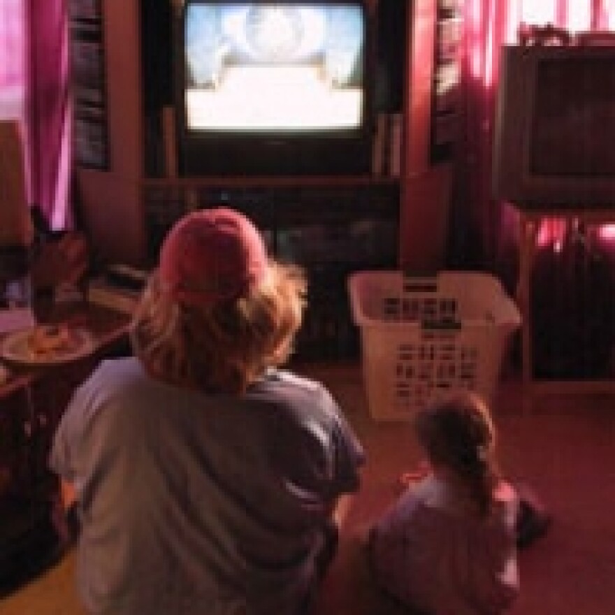 picture of kids sitting in floor watching a television