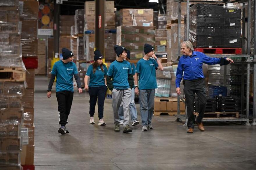 Rock Bridge High School students and JustServe volunteers take a tour at The Food Bank for Central and Northeast Missouri with Chief Operations Officer Daryle Bascom, right, on Wednesday at the Food Bank. The students started the JustServe club at their school with advisor Donny Silver to serve the community.