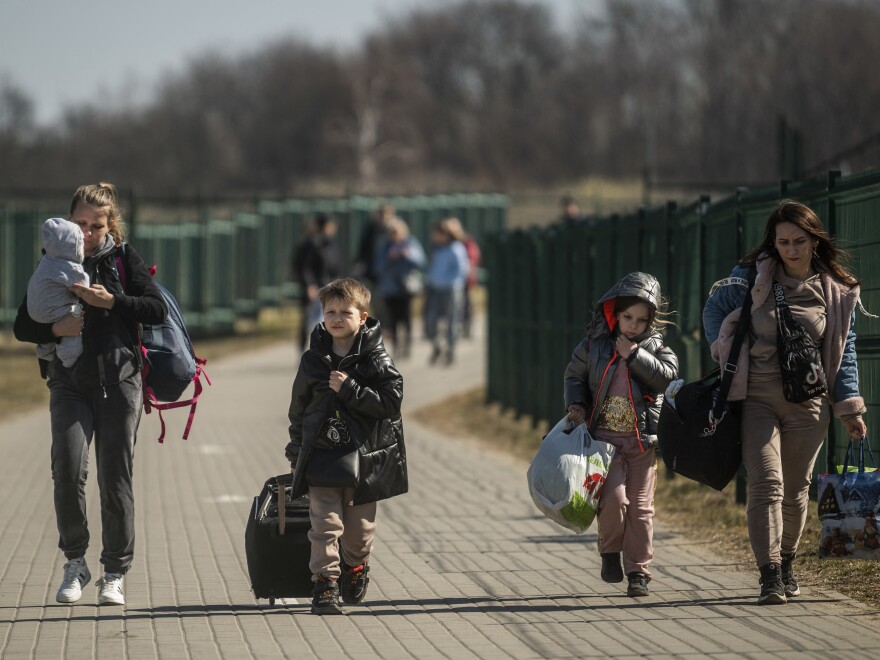 Refugees from Ukraine cross the border at the border crossing in Medyka, southeastern Poland.