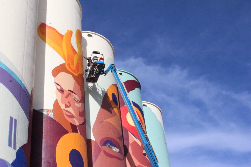 Colombian street artist GLeo perfects a flower on her world-record mural.