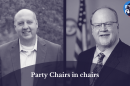 On the left is a monochromatic photo of Curtis Hertel. On the right is a monochromatic photo of Jim Runestad. At the bottom is an opaque, semi-circle with the words "Party Chairs in chairs". In the top right corner is the It's Just Politics logo.