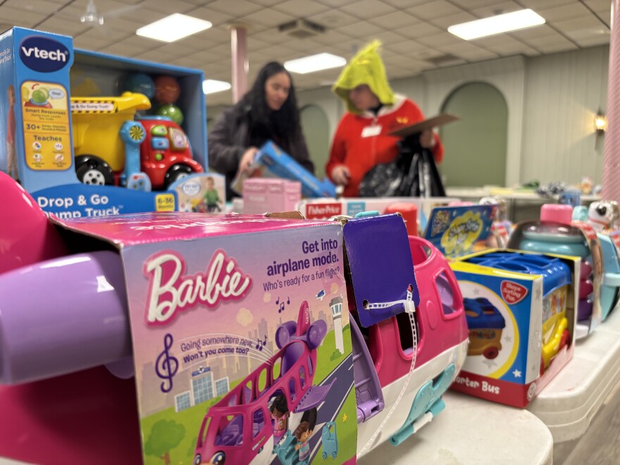 Trish Smith helps a "shopper" find Christmas gifts at Gifts for Kids.