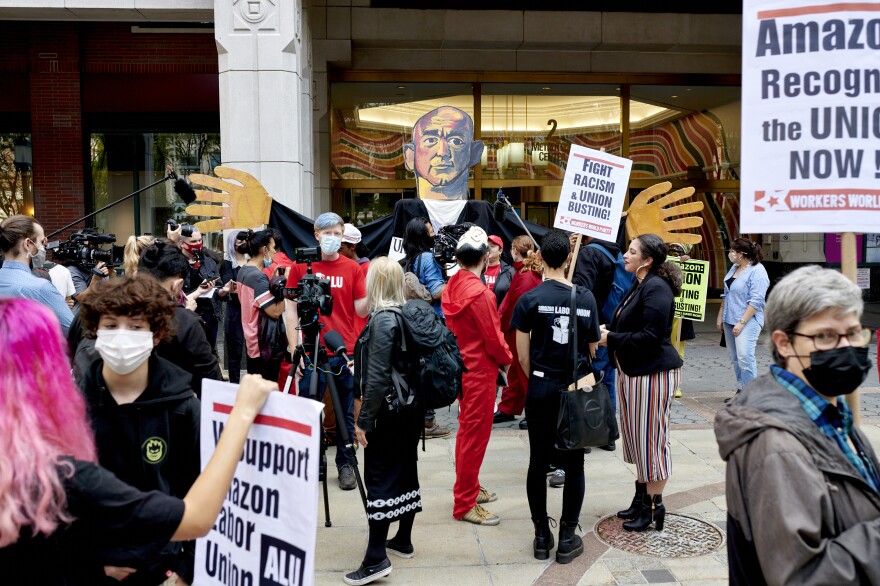 Workers and supporters hold signs after filing a petition requesting an election to form a union outside the National Labor Relations Board (NLRB) regional office in the Brooklyn Borough of New York, U.S., on Monday, Oct. 25, 2021. Amazon.com Inc. workers hoping to unionize four company facilities in Staten Island formally filed a petition with federal labor officials to hold a union election.