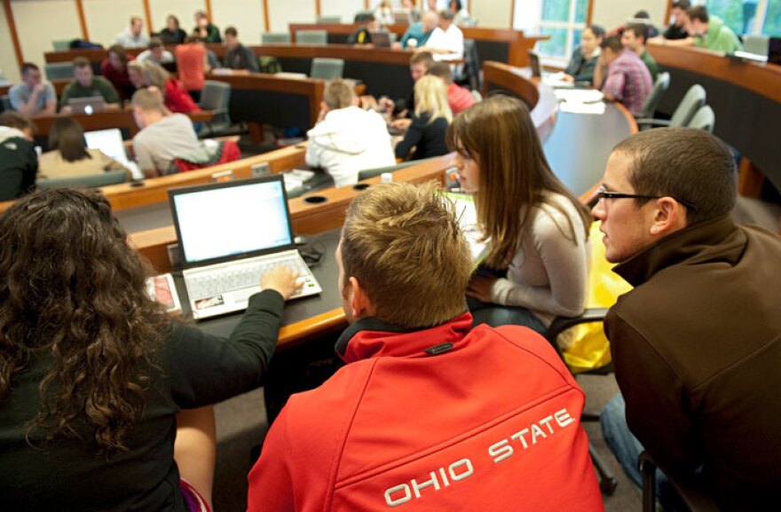 Students gather around a laptop computer in an Ohio State University classroom.