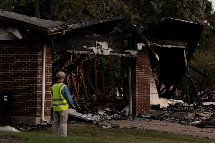 Workers assess damage near homes destroyed in a massive explosion of unknown cause on Monday, Aug. 25, 2025, near Black Jack. The blast destroyed at least five homes and damaged more than 20 others, leaving the neighborhood washed in debris.