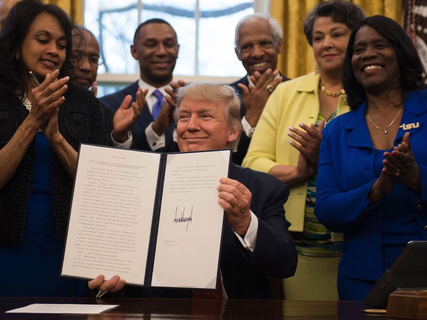 President Trump holds up an executive order to bolster HBCUs after signing it in the Oval Office on Tuesday.